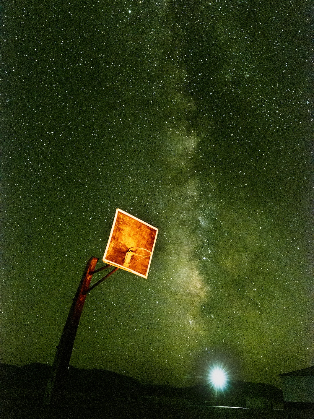 A basketball hoop in front of the night sky